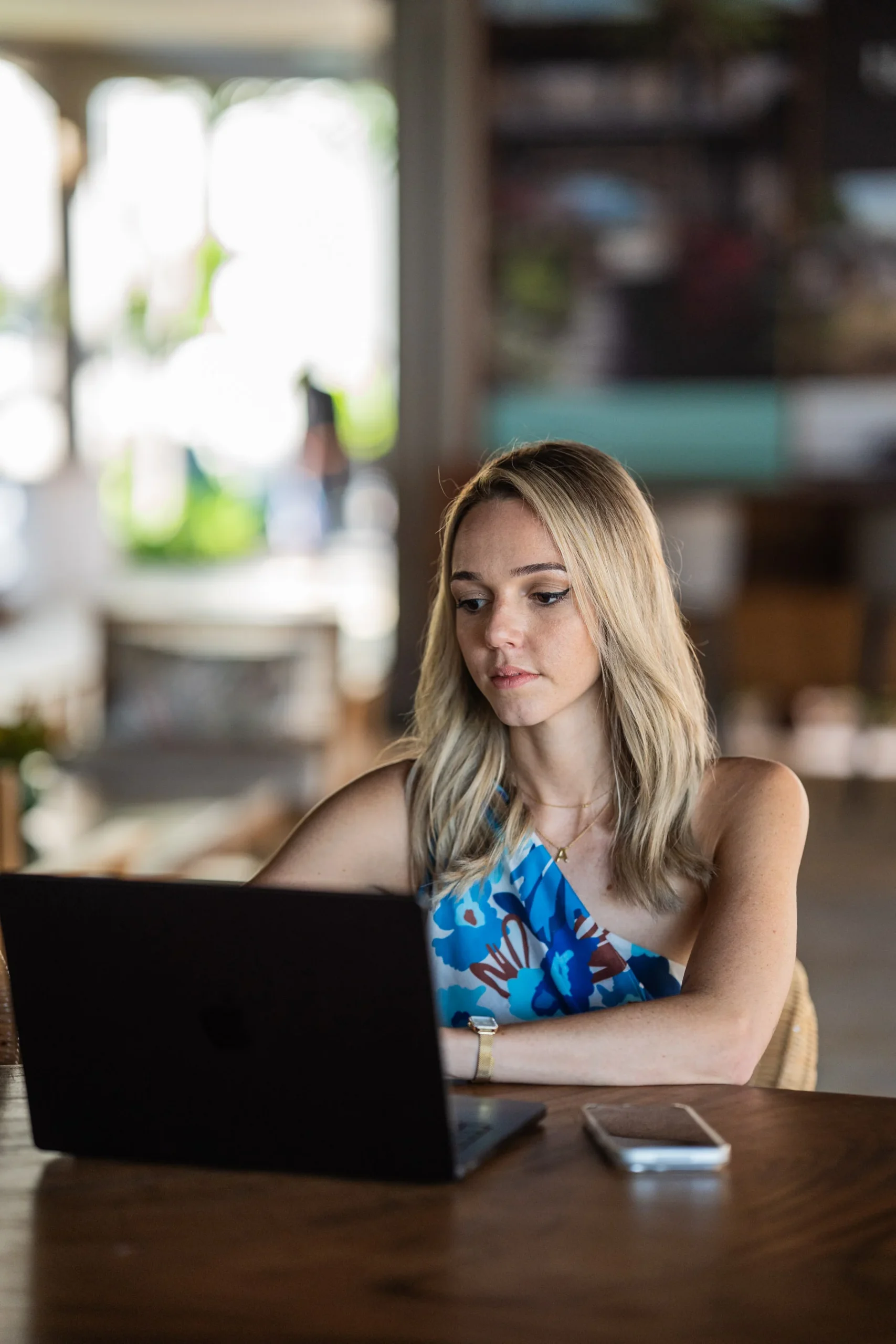Entrepreneure nomade concentrée sur son écran d'ordinateur en voyage