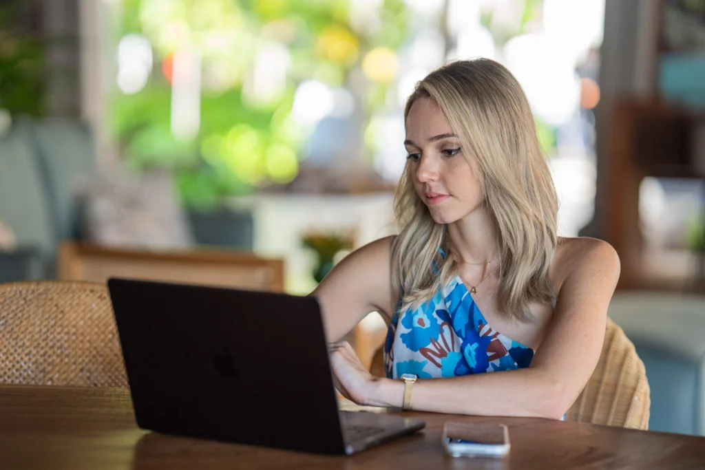 Femme gérant son entreprise sur ordinateur portable face à l'extérieur